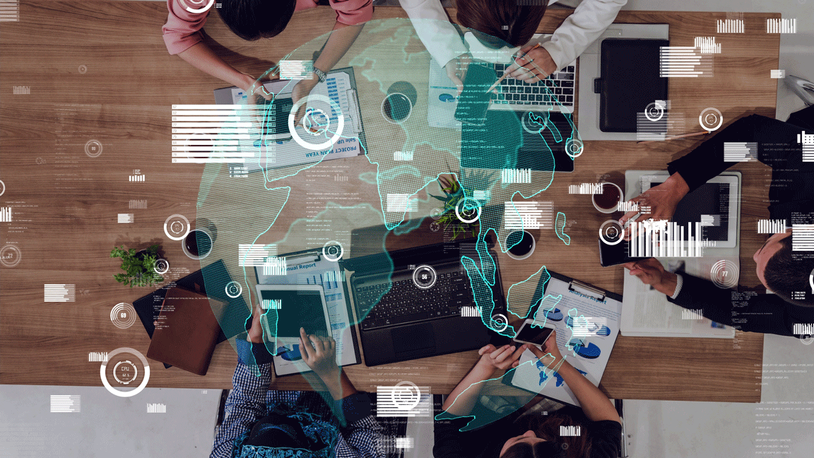 Group of professionals working together under a world map, representing global expansion and outsourcing strategies.